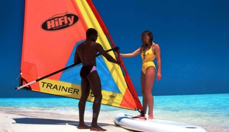 Muž učící ženu windsurfing 