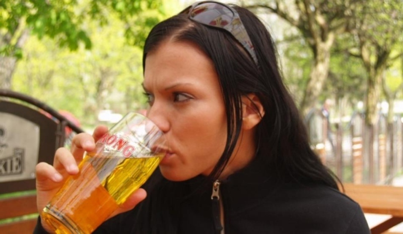Dívka pijící limonádu ze sklenice 