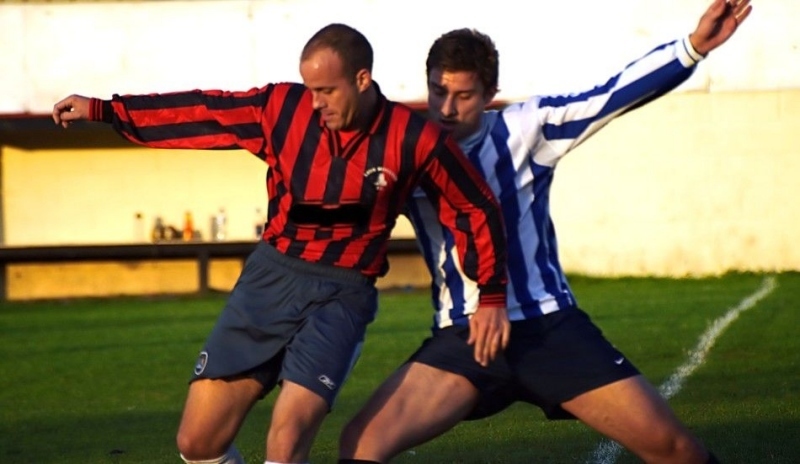 Muži v dresech soupeří o balón 
