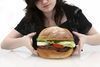 Žena držící v rukou obrovský hamburger 