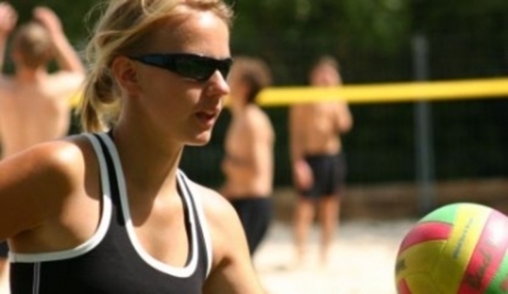 Žena s míčem na volejbalovém hřišti 