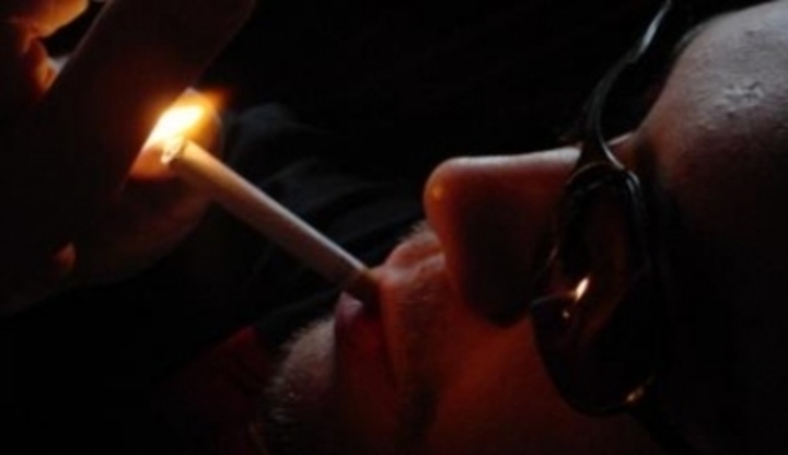 Muž zapalující si cigaretu