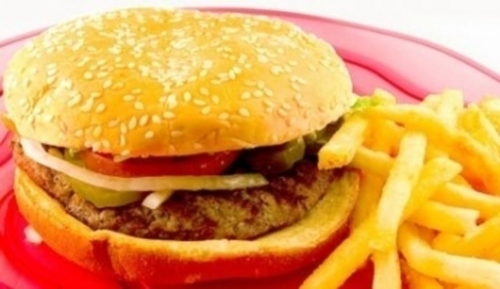 Hamburger s porcí hranolků na červeném talíři