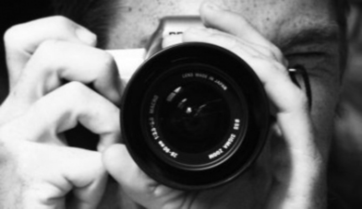 Muž držící fotoaparát před obličejem