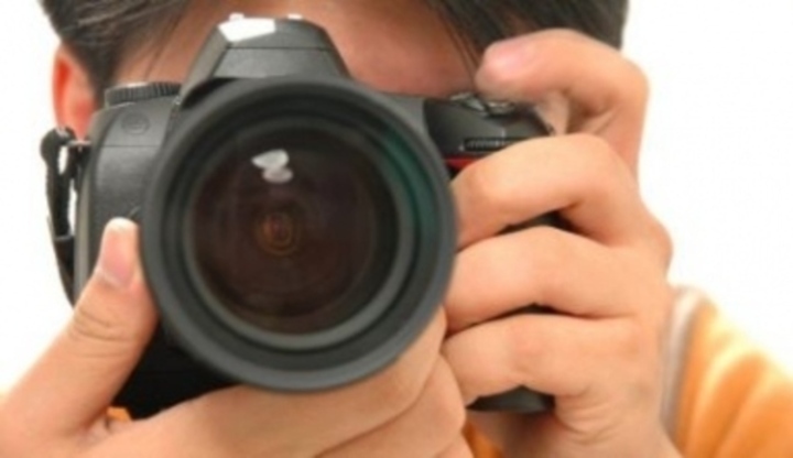 Muž držící fotoaparát před obličejem