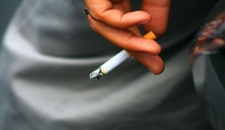 Ruka držící zapálenou cigaretu