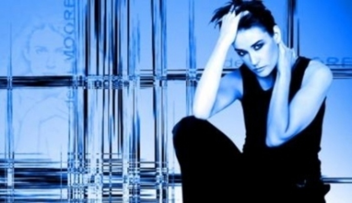 Klečící Demi Moore s rukou ve vlasech 
