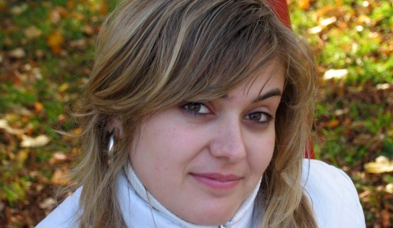 Žena v bílé bundě a zahaleným krkem 