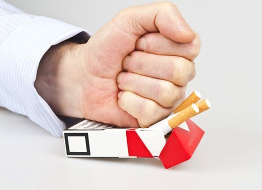 pěst mačkající krabičku cigaret
