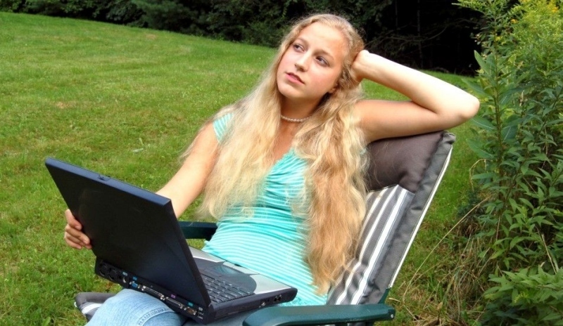 Sedící žena s notebookem v klíně 